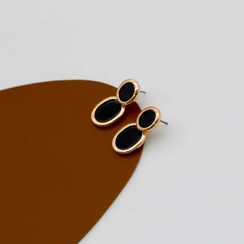 Brinco Preto Contorno Dourado